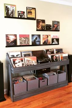 there is a record player on the shelf next to some bins with records in them