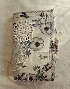 an old book with lace and flowers on it