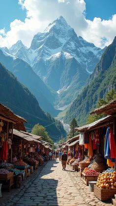 an outdoor market with mountains in the background and people walking down the street near it