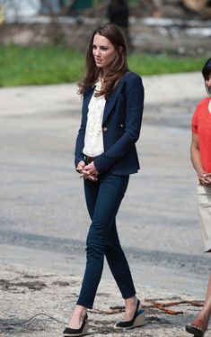 the woman is walking down the street with her hand on her hip and another person behind her