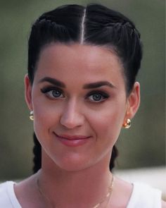 a close up of a person with a smile on their face and hair in a bun