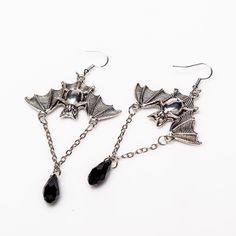 Unleash your inner darkness with these captivating Bat Earrings. Crafted from durable zinc alloy with a striking black finish, each earring measures 1.5 by 1 inch, featuring an elegant 1-inch chain adorned with a black diamond-shaped accent. Perfect for adding a touch of gothic charm to any outfit, these earrings are a must-have for your collection. Punk Alloy Jewelry For Halloween, Black Alloy Halloween Jewelry, Black Alloy Jewelry For Halloween, Nickel-free Alloy Earrings For Party, Edgy Black Alloy Jewelry, Edgy Black Sterling Silver Earrings, Black Edgy Sterling Silver Earrings, Black Vampire Jewelry For Halloween, Vampire Style Black Jewelry For Halloween