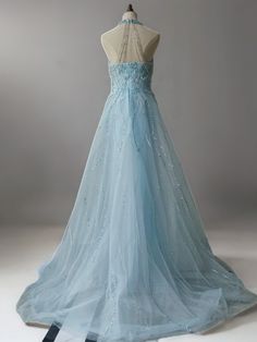 a light blue dress with beading on the back and neckline is displayed in front of a mannequin