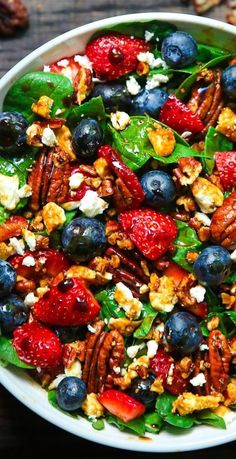 a white bowl filled with fruit and nuts