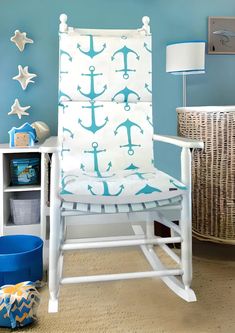 a white rocking chair with blue and white anchors on it in a child's room