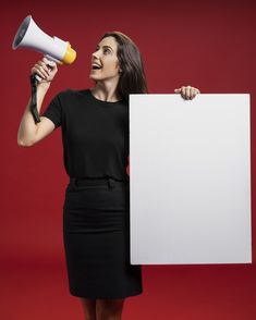 a woman holding a white sign and a megaphone in her hand while standing against a red background