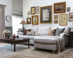 a living room filled with furniture and framed pictures on the wall above it's coffee table