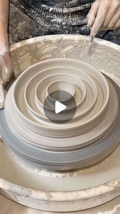 a person is making a vase out of clay