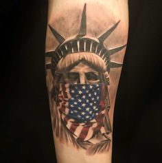 the statue of liberty with an american flag covering it's face