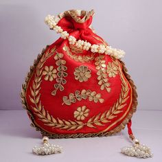 "Traditional India Handcrafted Gota Patti Work Potli Bag Golden Lace Embroidered Handbag For Wedding Bridal Bag Material:Golden Lace, Silk Fabric, Golden Thread, Motifs Color: Red, Pink, Gazri, Navy Blue Package Contents: As per quantity purchased Size: 10\" x 8\" Designed with the heart, this beautiful Potli or batawa bag are eye catchy and made of premium material. Key Features: Gota Patti Work This potli is good match with both Indian and western outfits and are superb for wedding and festive Traditional Gold Embroidered Fabric For Celebration, Red Rectangular Bags With Zari Work, Traditional Gold Embroidery Potli Bag, Red Bag With Zari Work For Festivals, Gold Embroidered Bags For Gifts, Festive Red Embroidered Bag, Festive Red Shoulder Bag With Handwork, Multicolor Embroidery Zari Work Potli Bag For Festivals, Traditional Resham Embroidery Potli Bag For Festive Season