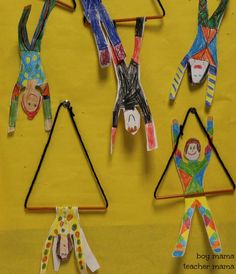 paper dolls hanging from clothes pins on a yellow background