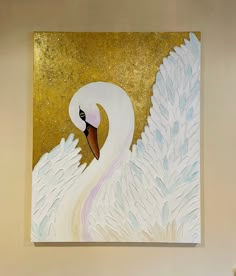 a painting of a white swan on a gold and white background is hanging on the wall