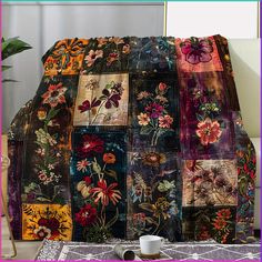 a couch covered in patchwork with flowers on it and a cup next to it