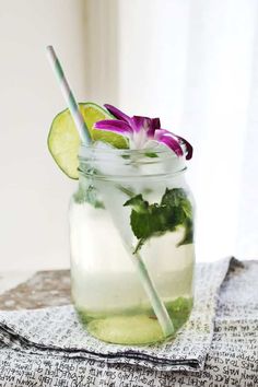 there is a mason jar filled with water and cucumber slices on the table