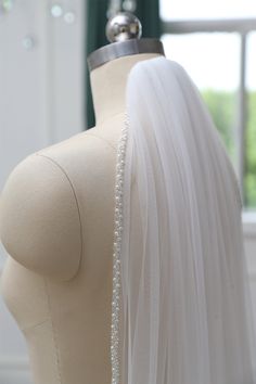 ➤The quality of the tulle is very sheer and veil is made to order. - Looks great with a variety of hairstyles. - Comes with a high quality metal comb and clear transparent seed beads, Pearls Crystal Edge Veil. ➤Available colors: white, dark ivory, light ivory, ivory, champagne.  ➤Size: 30'' Elbow (76cm) 38" Fingertip (96cm) 54" Waltz 1（137cm) 60'' Waltz 2 (153cm) 72'' Floor1 (183cm) 78" Floor2 (200cm) 90" Chapel (230cm) 108" Cathedral 1 (275cm) 118" Cathedral 2 (300cm) 137" Royal (350cm) 157" Regal (400cm) 177" (450cm) 196" (500cm) Custom Length ➤The length in the photo video is fingertip length (38'') ➤2Tiers veil is a blusher veil, it can cover the face. ➤It is handmade with very soft bridal illusion tulle and delicate pearls beads trim, definitely making you shine in your big day! ➤It w Pearl Beaded Veil, Pearl Edge Veil, Crystal Veil, Beaded Edge Veil, Beaded Bridal Veil, Simple Wedding Veil, Fingertip Length Veil, Beaded Wedding Veils, Simple Veil