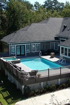 an aerial view of a house with a swimming pool in the yard and patio area