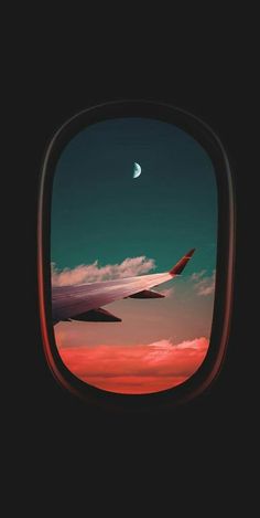 an airplane window looking out at the sky and clouds with a half moon in the distance