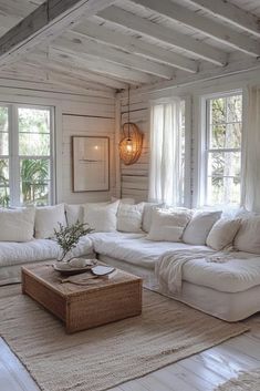 a living room filled with white furniture and windows