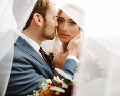 a bride and groom pose for a photo under the veil on their wedding day,