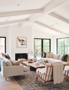 a living room with couches, chairs and tables in it's center area