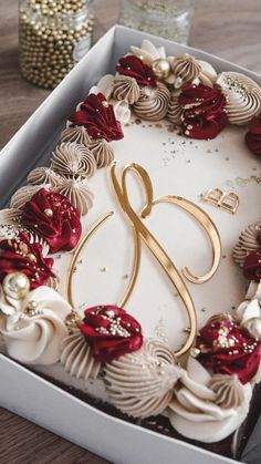 a cake with white frosting and red flowers in a box on a wooden table