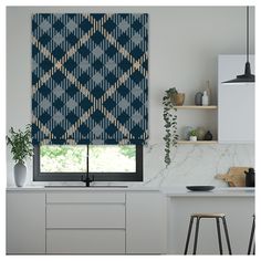 a kitchen with a window covered in blue and white patterned blinds next to a counter top