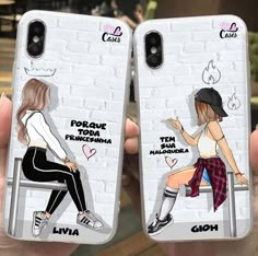 two people holding up cell phones with drawings on them