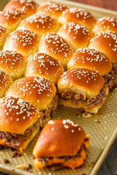 several sliders on a baking sheet with sesame seeds