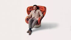 a man is sitting in an orange chair