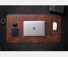 an apple laptop sitting on top of a desk next to a mouse and other items