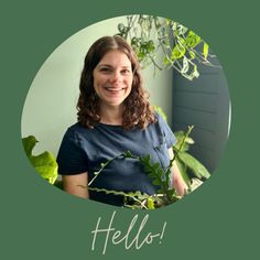 a woman is smiling while standing in front of a plant with the words hello written on it