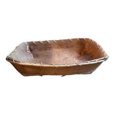 a wooden boat shaped bowl sitting on top of a white surface with roped handles