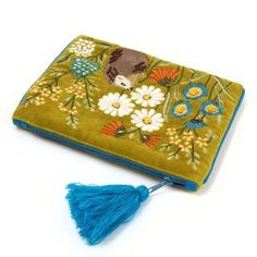 an embroidered wallet with a blue tassell and flower design on the front pocket