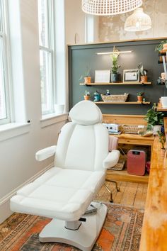 a white reclining chair sitting on top of a wooden floor next to a window