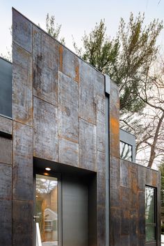 an exterior view of a modern home with metal cladding and wood accents on the walls