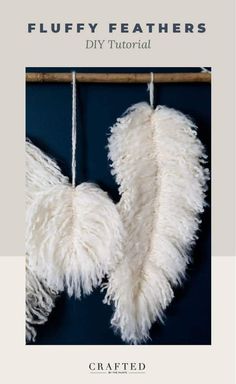 two white feathers hanging from a wooden frame with the words, fluffy feathers diy tutorial