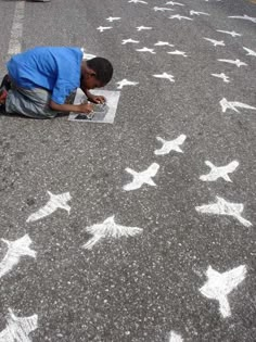 a man is drawing stars on the street