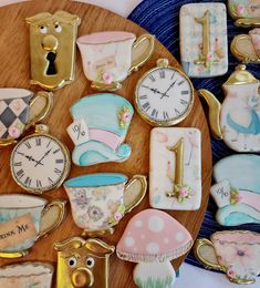 there are many decorated cookies on the wooden table with clocks and cupcakes in them