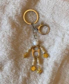 a keychain that is on top of a white blanket with stars and beads