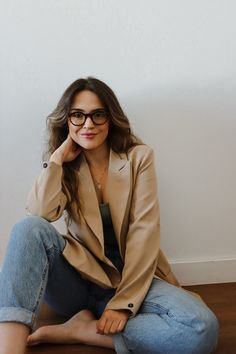 a woman sitting on the floor wearing glasses