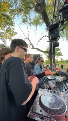 a group of people standing next to each other near a dj's turntable