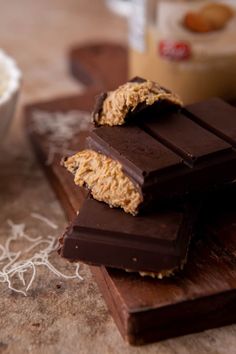 chocolate bars stacked on top of each other next to a cup of milk and spoon