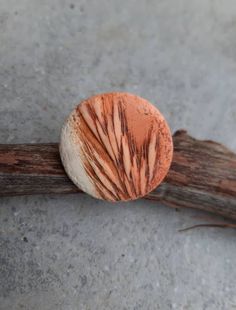 an orange and white object sitting on top of a wooden stick