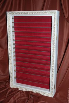 a red and white frame sitting on top of a brown cloth covered bed sheeted floor