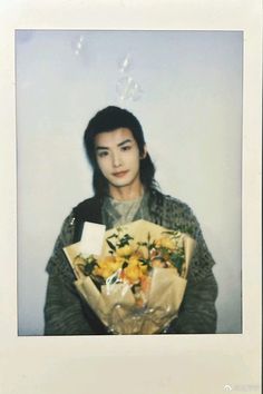 a woman holding a bunch of flowers in her hands