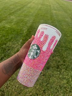 a hand holding a pink and white starbucks cup covered in swarong stars on it