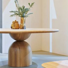 a wooden table with two vases on it and some plants in the middle one