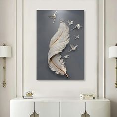 a white wall with a painting on it and some birds flying in the air next to it