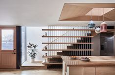 an open kitchen with wooden stairs leading up to the upper floor