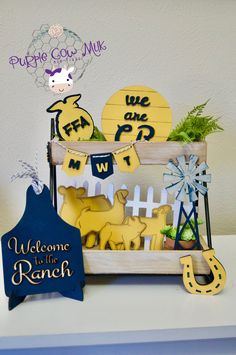 a welcome to the ranch sign and some decorations on a table with a cow theme